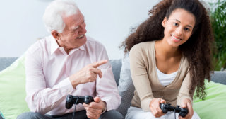 young woman and elderly man playing play-station